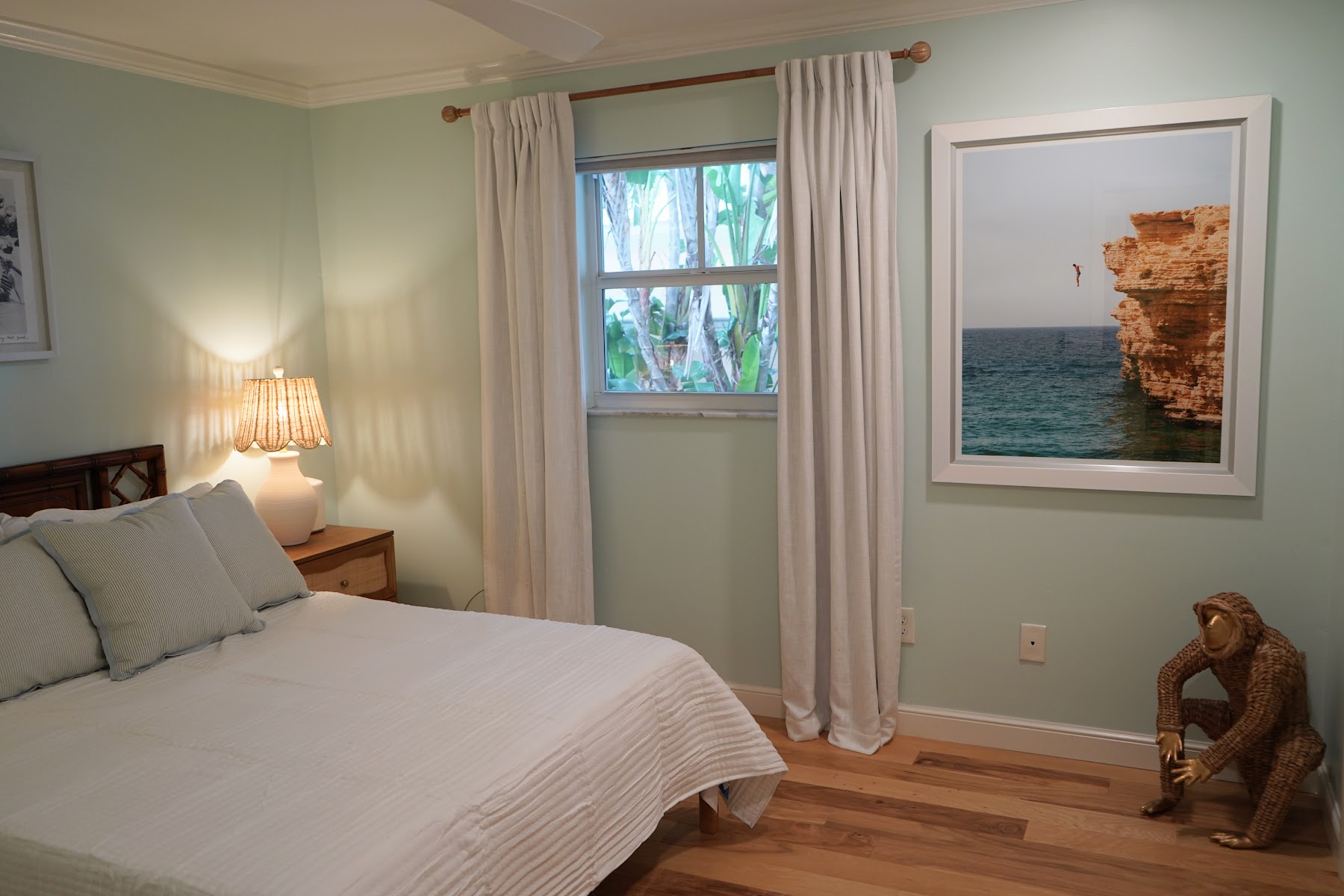 Guest bedroom with coastal art and garden view