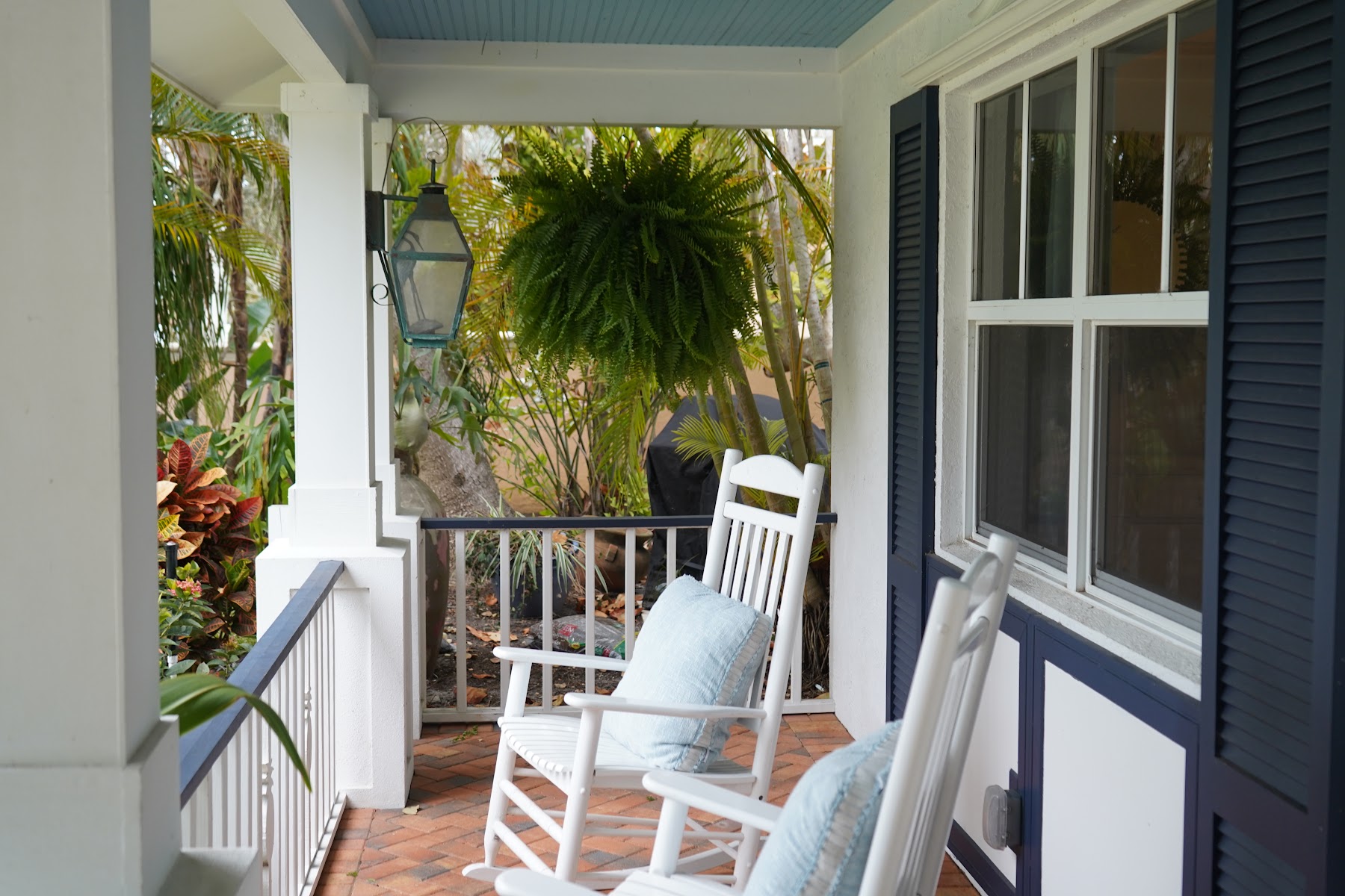 Front porch with rocking chairs and tropical plants